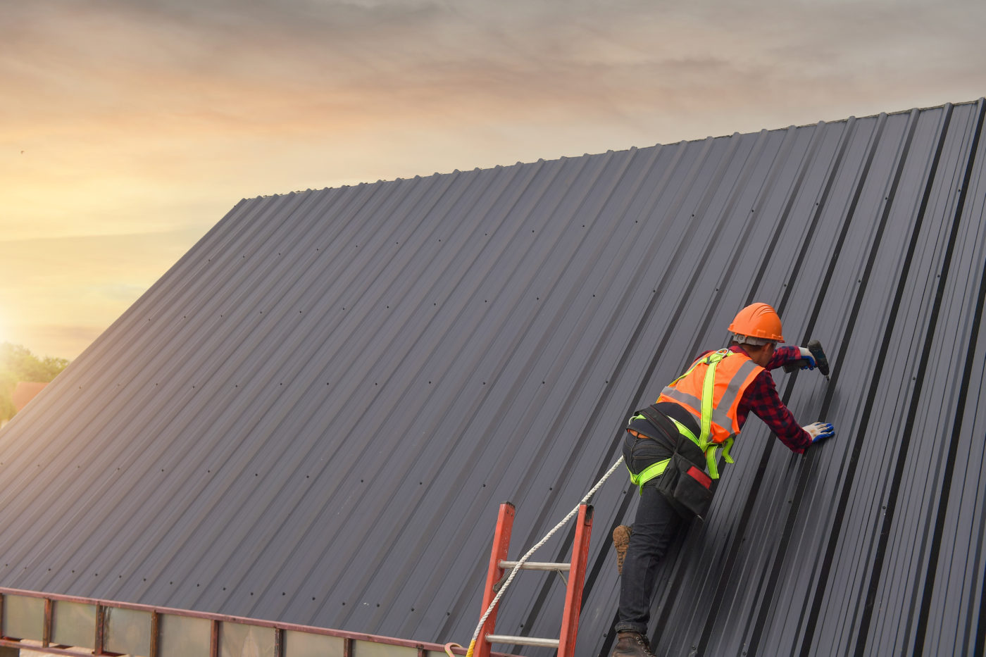 commercial metal panels-man on roof with drill