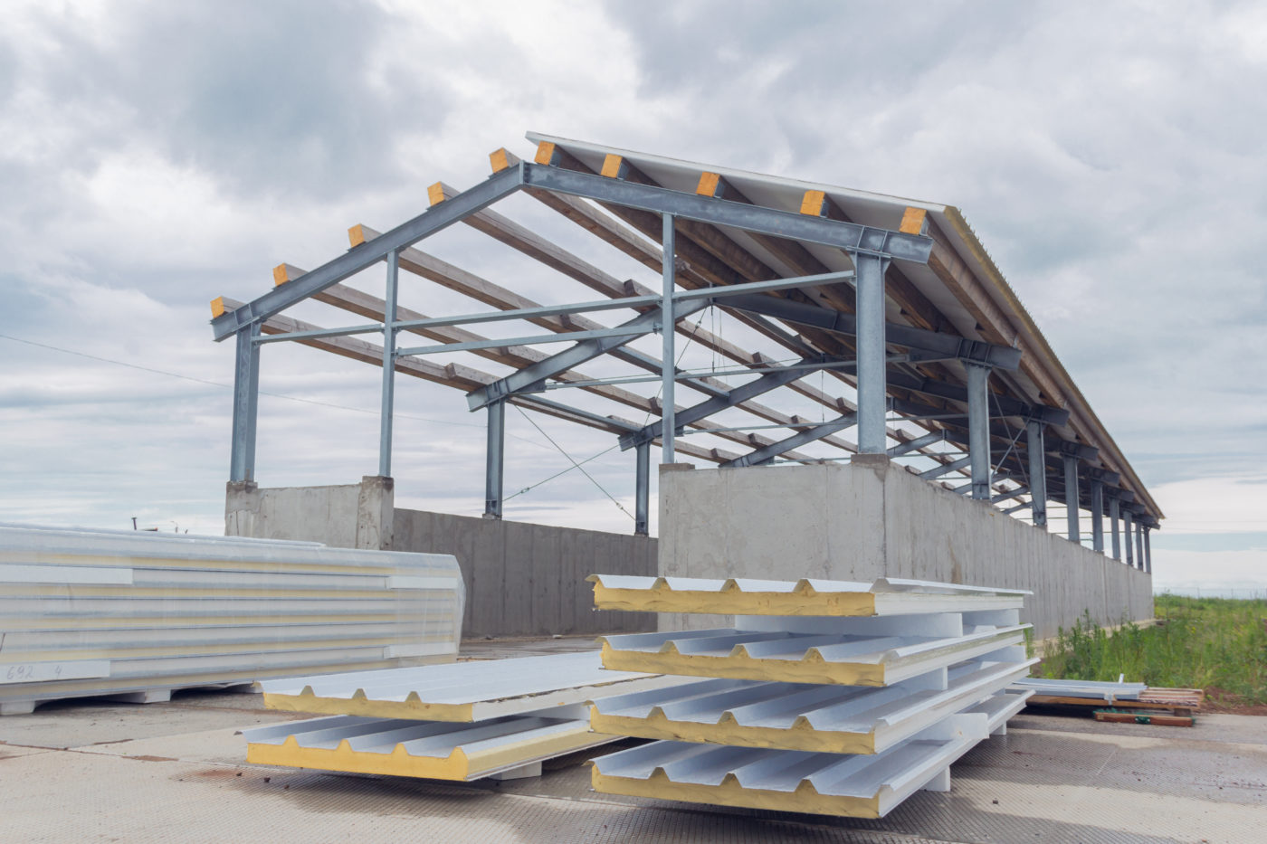 metal frame of the building with a sandwich panel of insulation on the wall construction of a new industrial building modern insulation of the walls of the building panels of insulation 